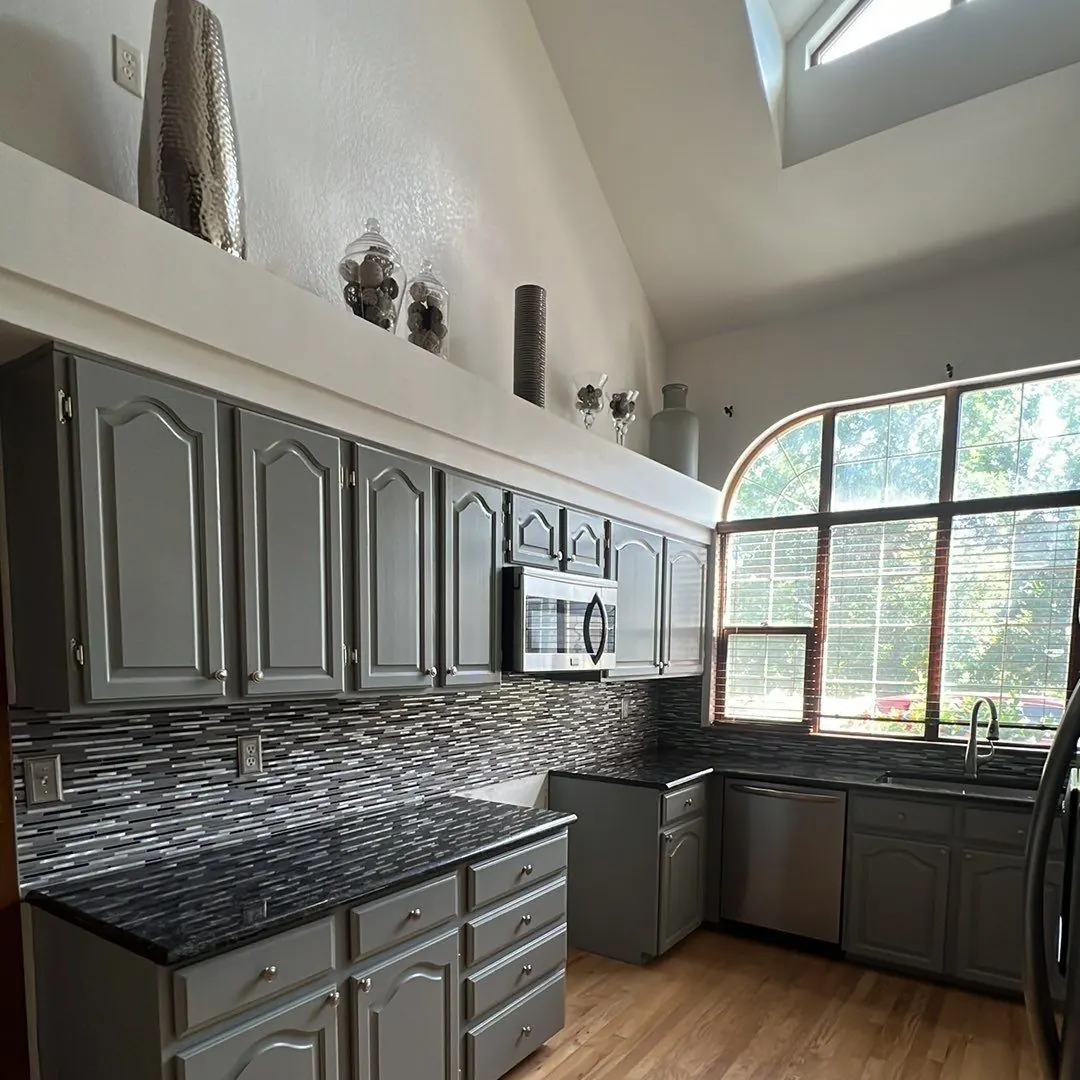 Floor-to-ceiling repainted cabinets around a kitchen window